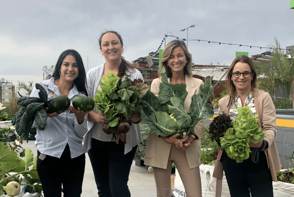 Cuatro mujeres parte del personal de Nuevocentro sosteniendo alimentos orgánicos que fueron sorteados.